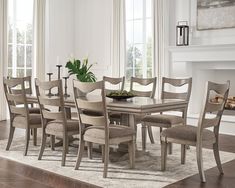 a dining room table and chairs in front of a fireplace