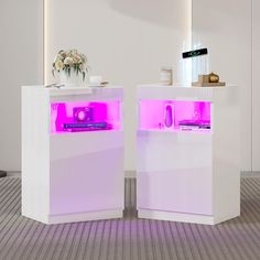 two white cabinets with pink lights on them in the middle of a carpeted room