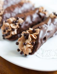 two chocolate desserts on a white plate sitting on a wooden table