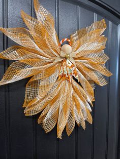 a wreath made out of mesh hanging on a door