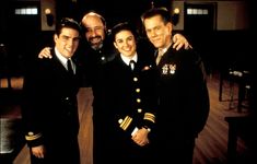 three men and one woman in uniform posing for the camera