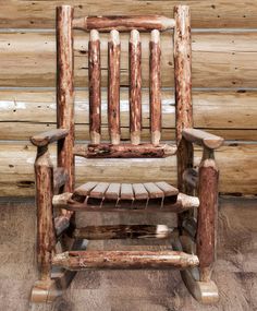 a wooden rocking chair sitting in front of a log wall