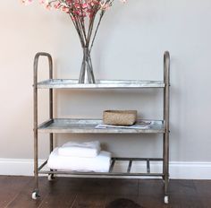 a metal shelf with flowers and towels on it