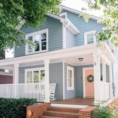 a blue house with white trim on the front porch and steps leading up to it