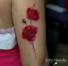 a woman's arm with three red flowers on it