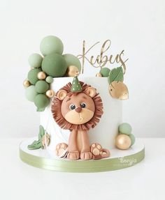 a birthday cake with a lion on top and decorations around the edges that say kubus