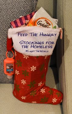 a red christmas stocking filled with candy and candies sitting on top of a couch