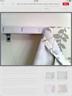 a curtain is hanging on the wall next to a towel rack with an object in it