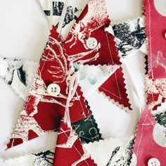 some red and white fabric pieces with buttons on top of each other in the shape of christmas trees