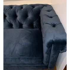 a blue couch sitting on top of a hard wood floor next to a white wall