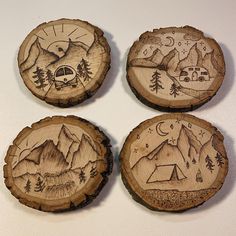 four wooden coasters with camping designs on them