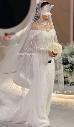 a woman in a white wedding gown and veil