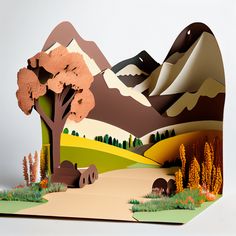 a paper cut landscape with mountains and trees