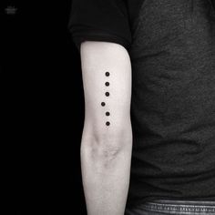 a man's arm with three dots on it