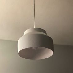 a white lamp hanging from the ceiling in a room with no one around it or someone else