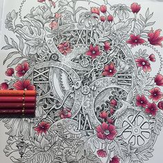 an intricate coloring book with flowers and clocks on it, next to two pencils