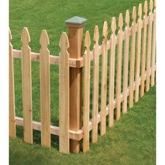 a wooden fence in the grass with a post