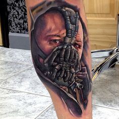 a man's leg with a tattoo on it that has an image of a batman