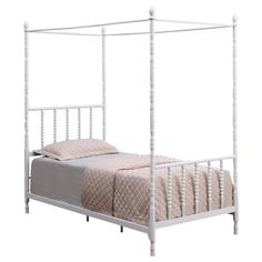 a white metal bed frame with four posts