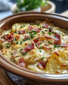 a dish with potatoes and ham in a brown bowl on a wooden table next to other dishes