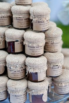 several jars of jam are stacked on top of each other in burlap bags