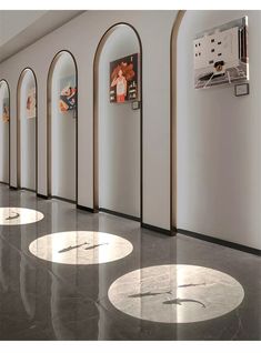 an empty hallway with arches and paintings on the walls