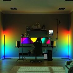 a person sitting at a desk in front of a tv with rainbow colors on the wall