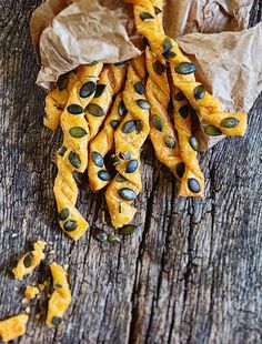 some kind of food sitting on top of a wooden table next to a bag filled with seeds