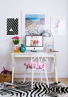 a white desk with a computer on top of it next to pictures and vases