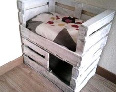 a bed made out of wooden pallets with a blanket on top and pillows in the bottom