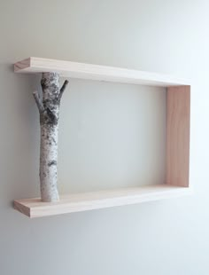 two wooden shelves on the wall with a tree in them