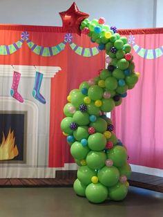 a green balloon tree in front of a fireplace