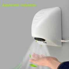 a person's hand is sprinkling water from an automatic soap dispenser