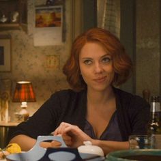 a woman is sitting at a table with food