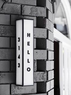 there is a sign that says hello on the side of a brick building with black and white letters