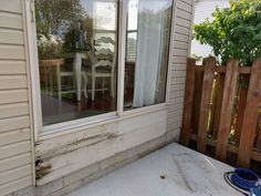 a table and chairs sitting on the outside of a house next to a wooden fence