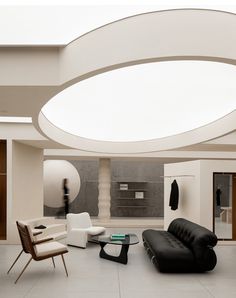 a living room filled with furniture and a large circular light fixture hanging from the ceiling