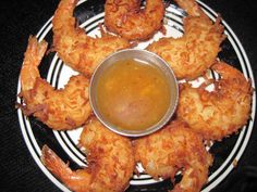 fried shrimp with dipping sauce on a black and white plate, ready to be eaten