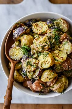 a white bowl filled with potatoes and other vegetables