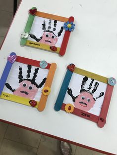 two children's handprints are displayed in frames on a white table top