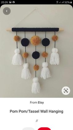 a mobile phone with an image of pom - tassel wall hanging on it