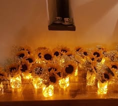 sunflowers are lit up in mason jars on a table