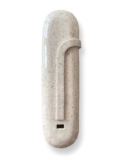 a white ceramic object with a black handle on it's back end, against a white background