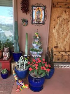 several potted plants are on the front porch with an image of jesus above them