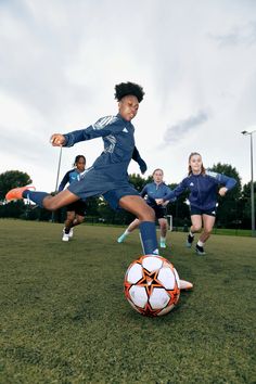 a group of young women kicking around a soccer ball