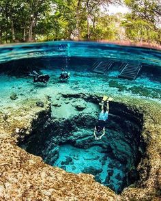 an underwater view of a man swimming in the ocean with his feet up on the ground