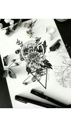 some flowers are sitting on a table next to pens and ink pads, with other items surrounding it