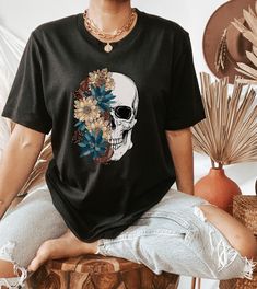 Bloom Flower Skull Shirt, Halloween Shirt, Floral Skull Boho Graphic Tee, Womens Fall Shirt, Halloween Skull Tee, Skeleton TShirt, Skeleton Blooms Are you looking for additional Fall or Halloween themed graphic tees? Check out the following: https://www.etsy.com/shop/TheGraphicPeach?ref=seller-platform-mcnav§ion_id=30182981 For environmental and human friendly reason, this product is only made when you order. Turnaround time is usually 1-5 business days before shipping, but can increase during h Skull Shirts Vinyl, Black Tshirt Design Ideas Graphic Tees, Casual Skull T-shirt For Fall, Skeleton Tshirt Design, Day Of The Dead Skull Print Short Sleeve Tops, Black Graphic Print Top For Day Of The Dead, Trendy Tshirts Graphic Tees Design, Boho Graphic Tees, Skull T Shirts