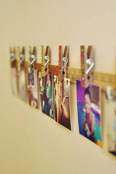 several photos hanging on a wall with a measuring tape attached to the pegs that hold them