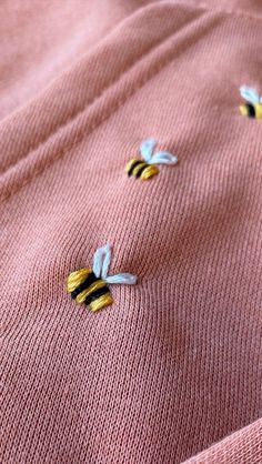 two yellow and white flowers are on the pink knitted sweater that is worn by someone